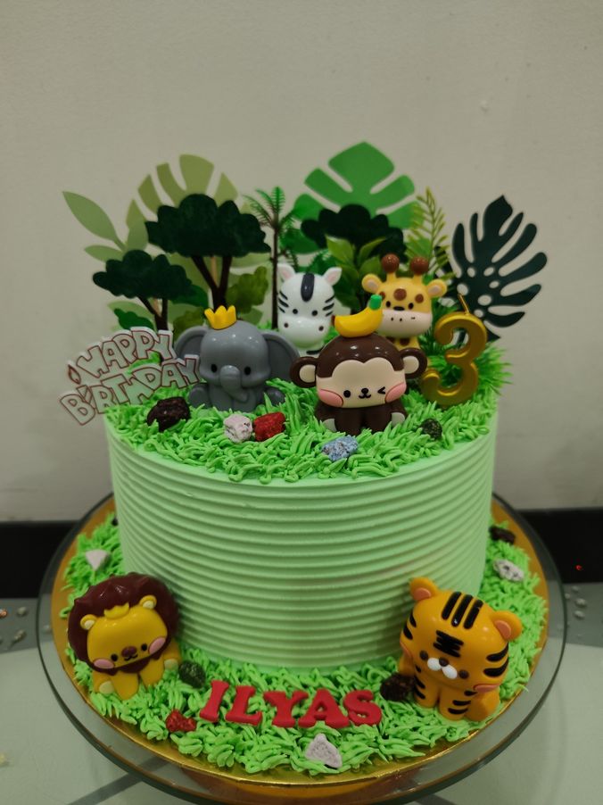 Kek hari jadi hijau bertema dunia haiwan dengan singa, harimau, gajah, monyet, zirafah dan zebra